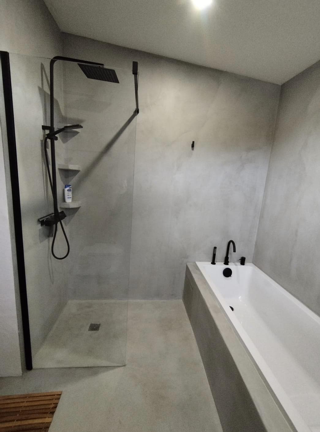 Baño de ODISHOW con paredes y suelo continuos de microcemento