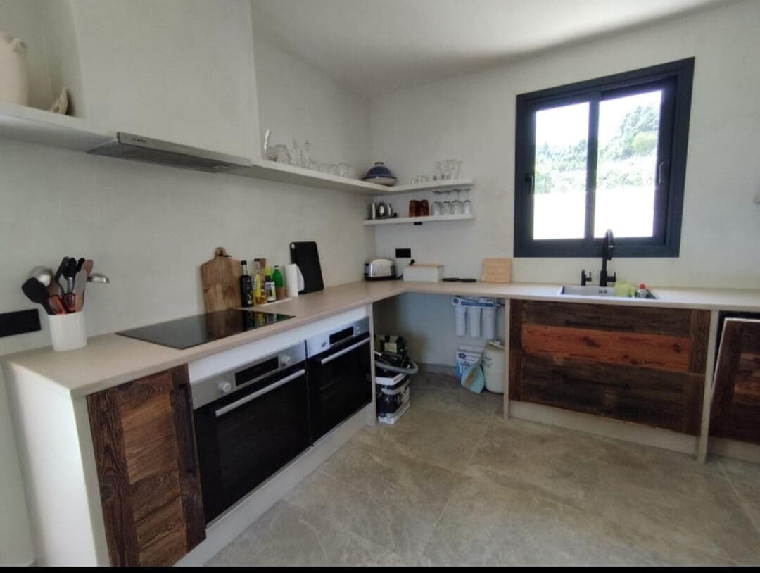ODISHOW kitchen combining microcement surfaces with timber cabinetry